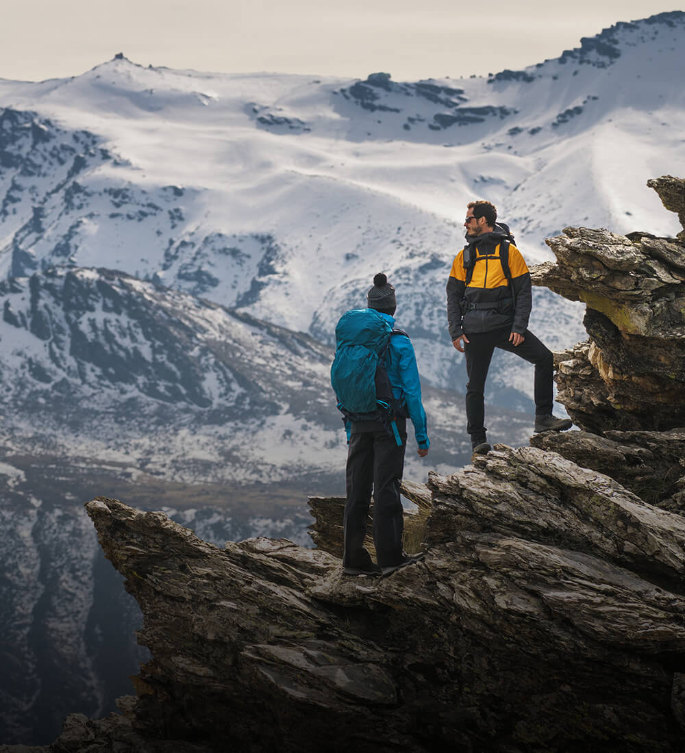 Zwei Personen, die auf eine schneebedeckte Gebirgskette blicken