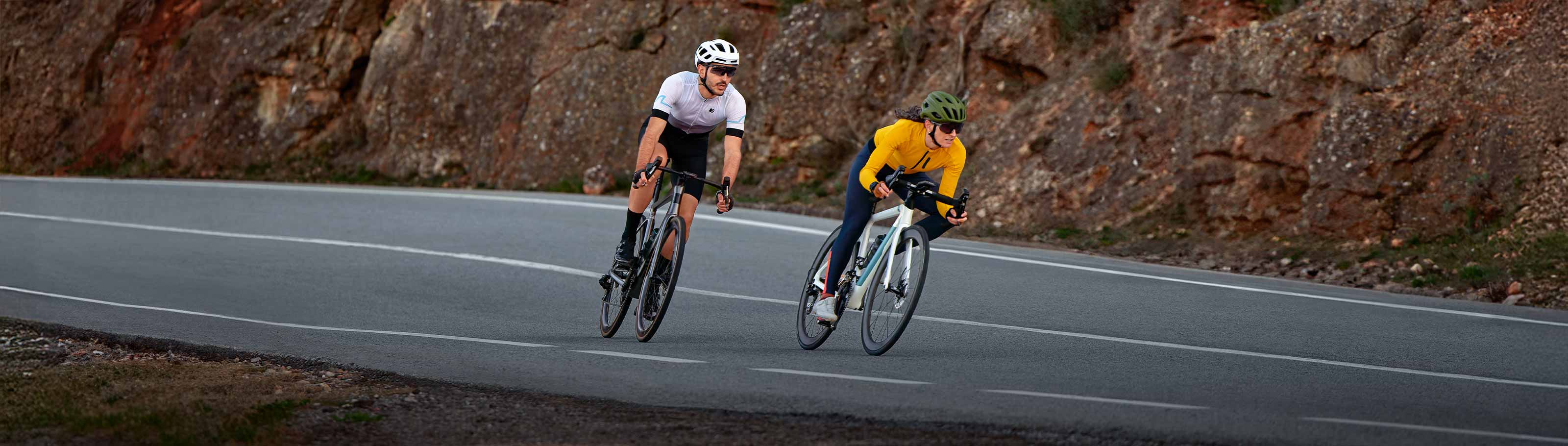 Zwei Personen auf Rennrädern, die durch die Berge fahren