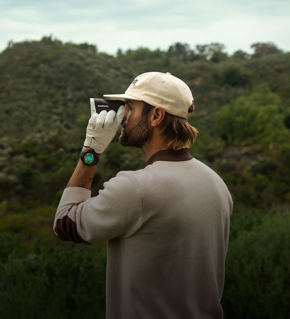 Golfer, der auf einem Golfplatz einen Entfernungsmesser verwendet